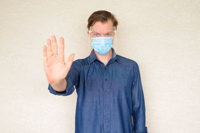 Portrait of man standing against white background