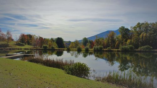 Scenic view of lake by trees against sky