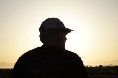 Rear view of silhouette man against sky during sunset