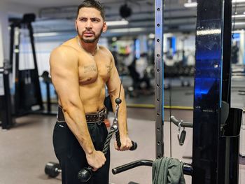 Full length of shirtless man looking at camera