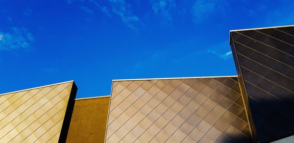 Low angle view of modern building against clear blue sky