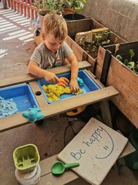 High angle view of boy sitting on table