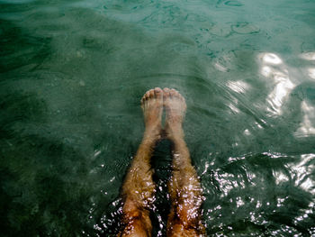 Low section of man swimming in sea