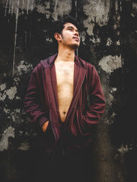 Young man standing against wall