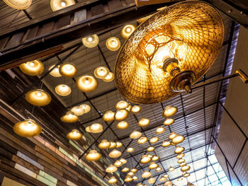 Low angle view of illuminated chandelier hanging from ceiling