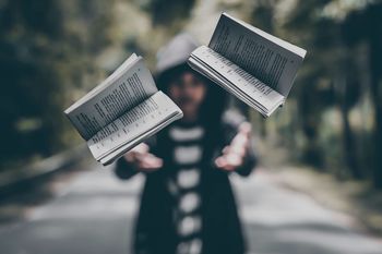 Man throwing books while standing on road