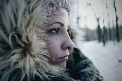 Close-up portrait of young woman in snow