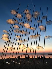 Silhouette people on beach against sky during sunset