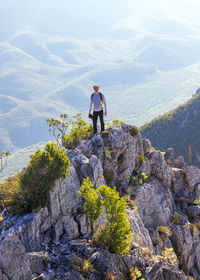 Man standing on rock against mountains
