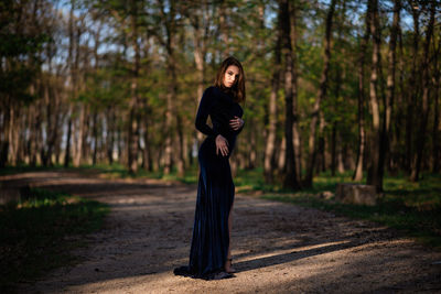 Full length of woman standing in forest