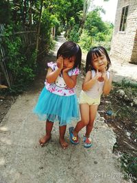 Siblings standing against trees