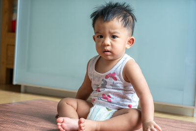 Cute boy looking away while sitting at home