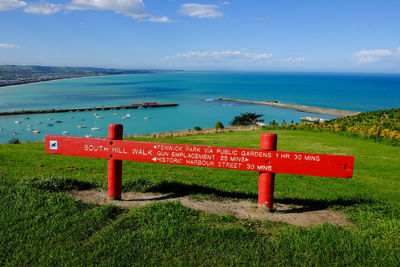 Information sign by sea against sky, in new zealand. travel around. 