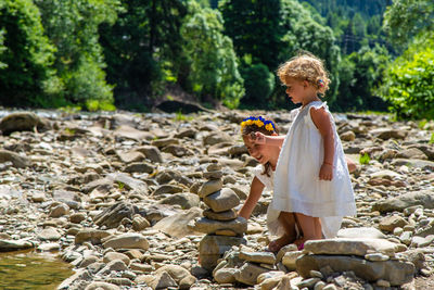 Full length of young woman standing on rock