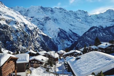 High angle view of buildings and snowcapped mountains against sky