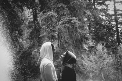 Low section of person standing by trees in forest