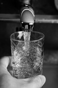 Close-up of hand filling water in glass from faucet