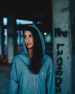 Portrait of beautiful young woman standing at night