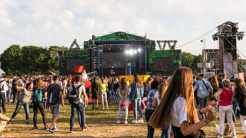 Crowd at music concert against sky