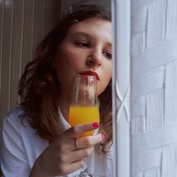 Portrait of young woman drinking orange juice 