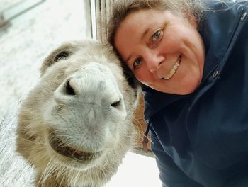 Portrait of smiling young woman with donkey