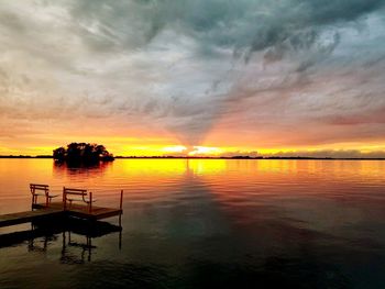 Scenic view of sea against dramatic sky during sunset