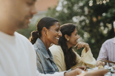 Happy mature woman having lunch with family members during social gathering