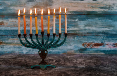 Illuminated candles on shore