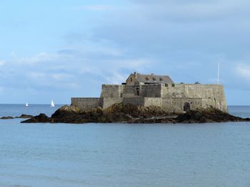 Building by sea against sky