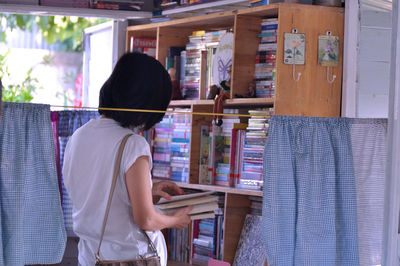 Rear view of woman standing at store