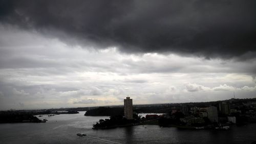 River in city against cloudy sky