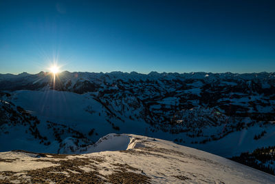 Scenic view of snowcapped mountains against clear blue sky