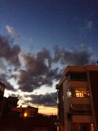 Buildings against cloudy sky at sunset