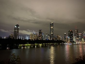 Illuminated buildings in city against sky at night