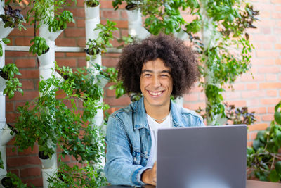 Portrait of woman using digital tablet while sitting at table