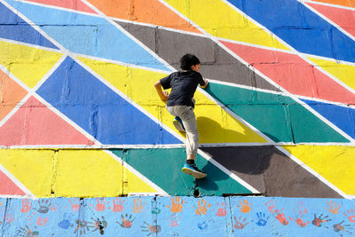 Optical illusion of boy climbing wall