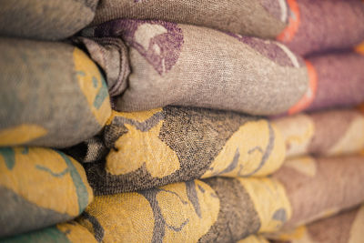 Samples of linen fabrics in a pile on store shelf.