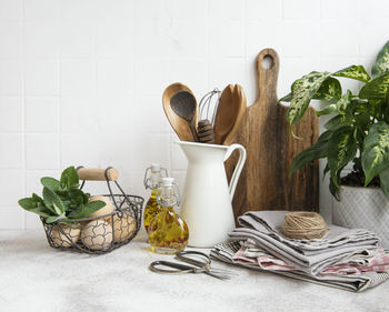 Kitchen utensils, tools and dishware on on the background white tile wall. 