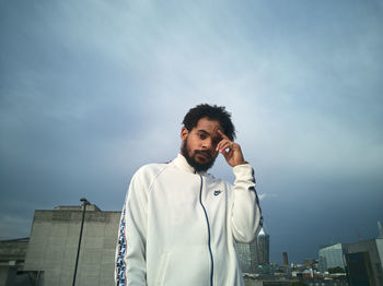 Portrait of young man standing against sky