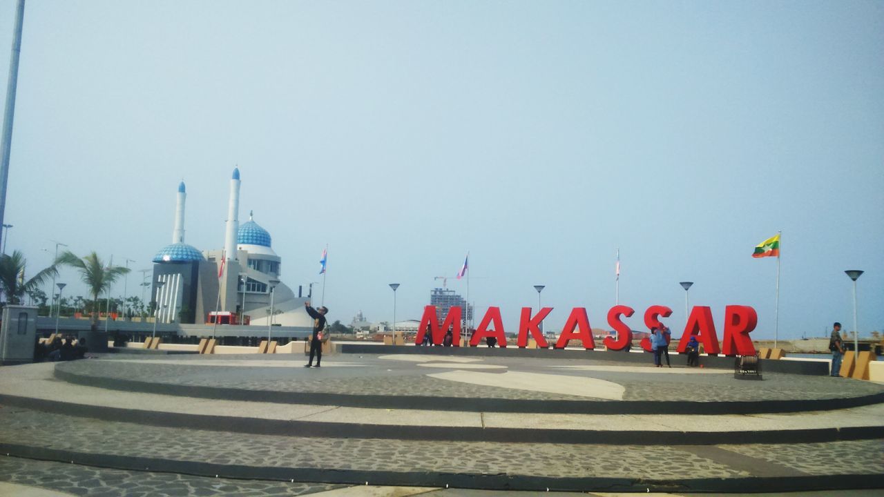 clear sky, copy space, transportation, road, street light, road marking, mode of transport, men, sky, flag, street, outdoors, built structure, day, travel, incidental people, leisure activity, lifestyles, land vehicle