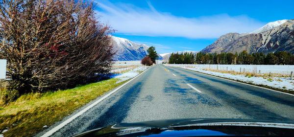 Road amidst trees against sky