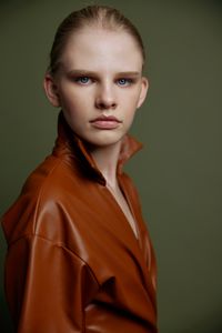 Portrait of young woman against gray background