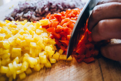 Cropped hand of person cutting vegetables on table