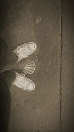 Low section of person standing on tiled floor