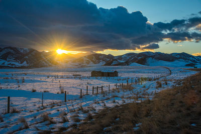 Scenic view of frozen lake against sky during sunset