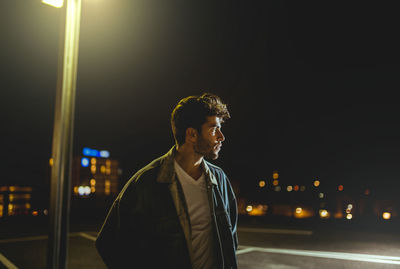 Man in illuminated city against sky at night