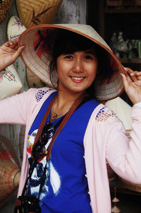 Portrait of smiling young woman holding hat