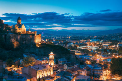 Aerial view of illuminated buildings in city at dusk