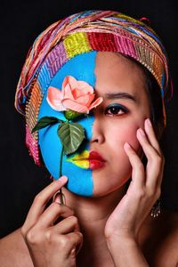 Portrait of woman wearing hat against black background