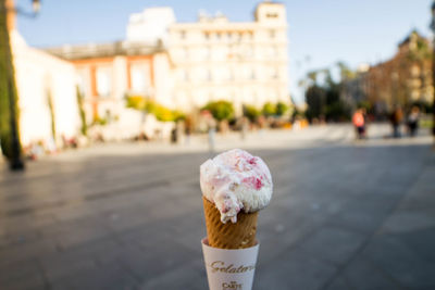 Ice cream cone against buildings in city